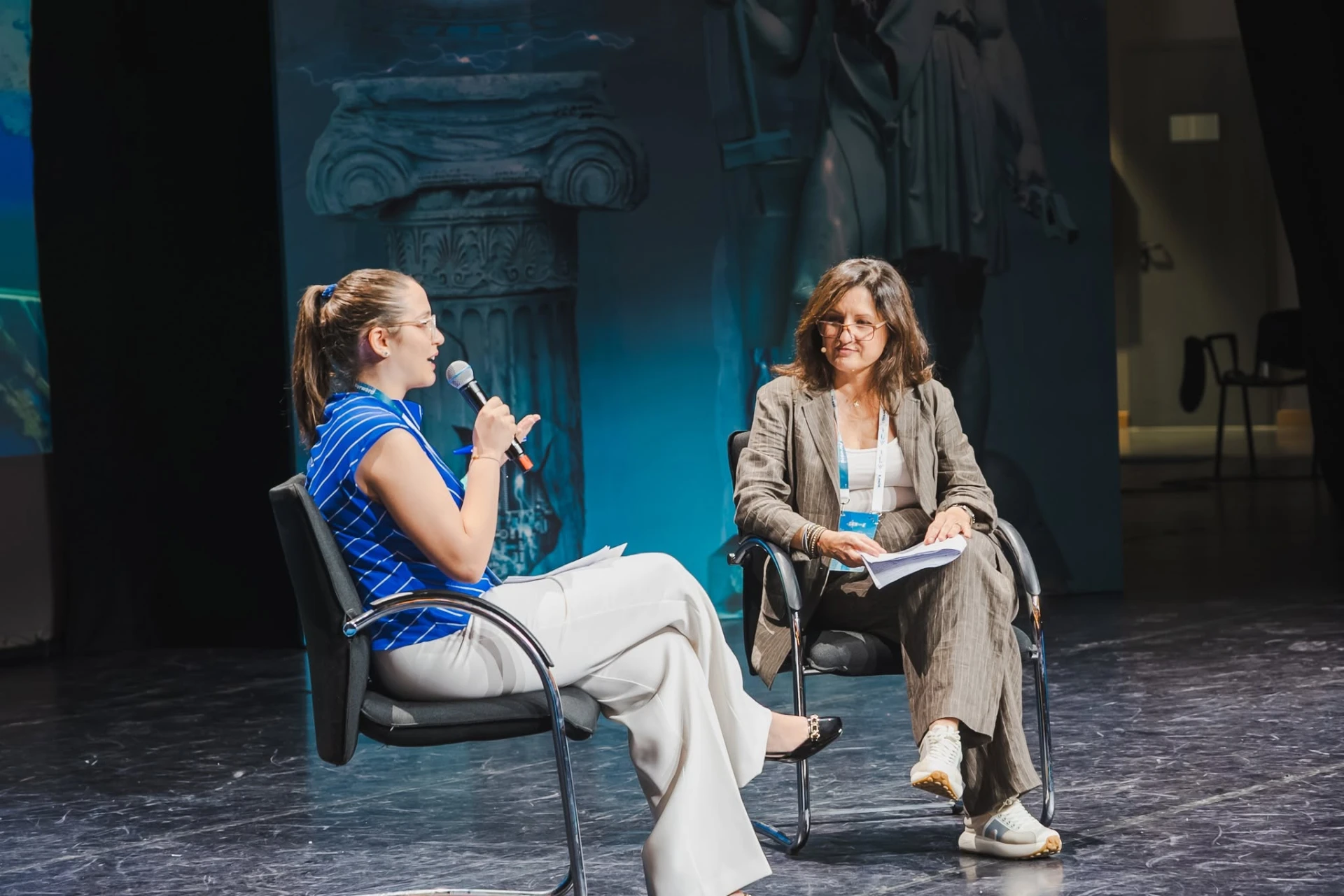 Two women in conversation during a fireside chat on stage