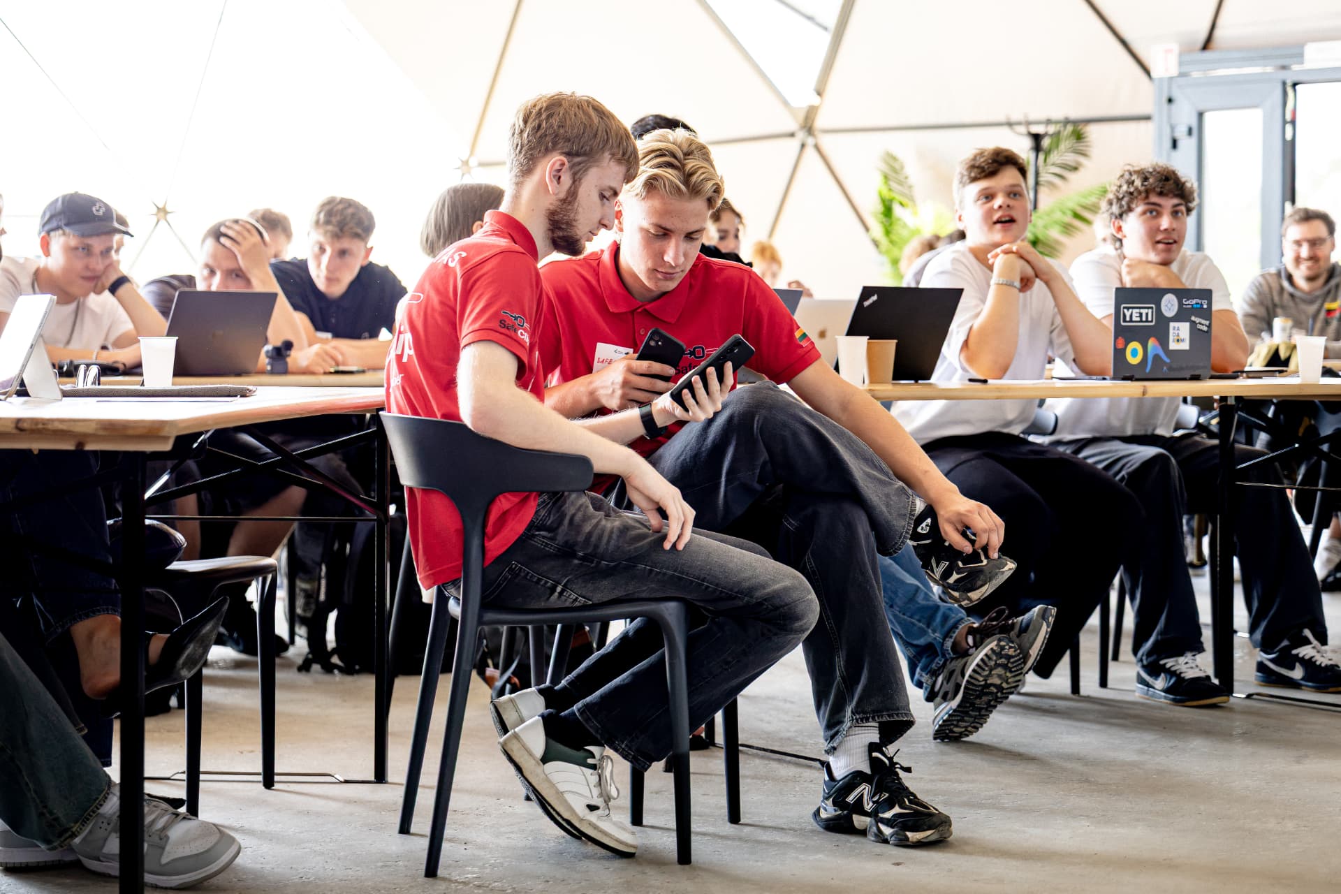 Two young founders reviewing their idea on a phone during a bootcamp